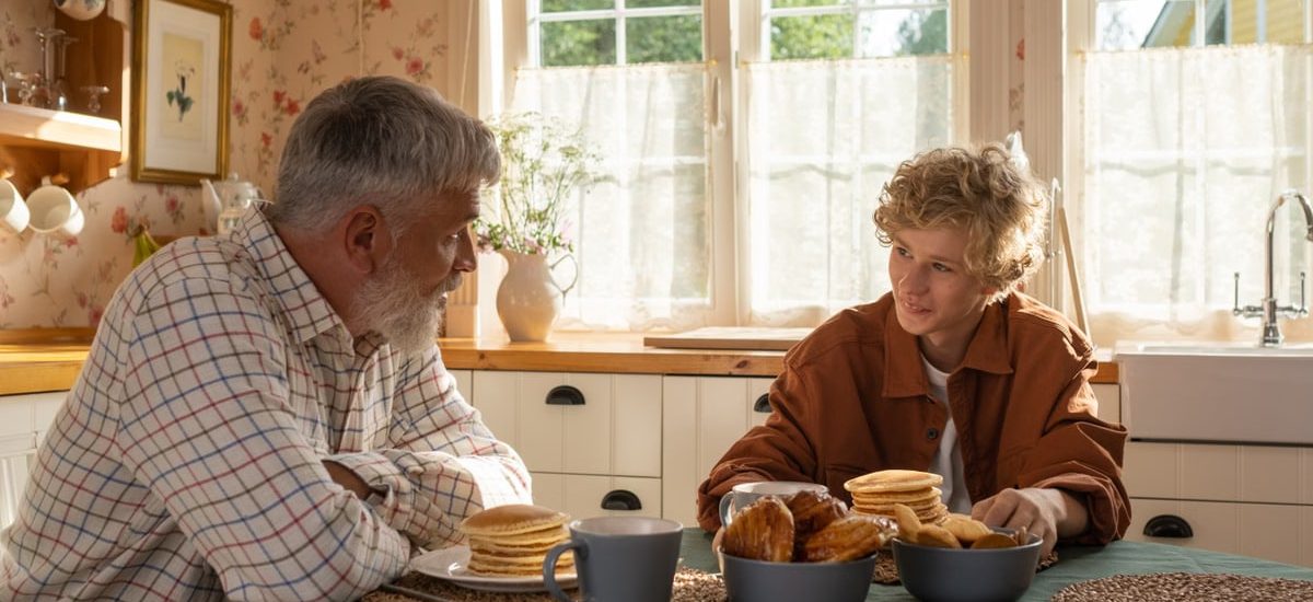 A serene morning breakfast setting with grandfather and grandson sharing pancakes and togetherness.