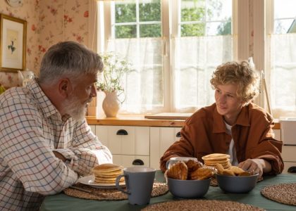 A serene morning breakfast setting with grandfather and grandson sharing pancakes and togetherness.